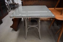 A Lloyd Loom square table having glass top, approx 76 x 76cm