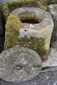 A hand carved stone planter or water trough with grinding stone