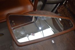 A vintage teak wall mirror, stylised shape