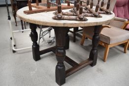 A traditional oak circular dining table having stripped top and heavy turned frame