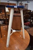 A lab style stool having wood frame with metal supports to triple splay legs