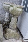 An impressive pair of Victorian hand carved stone garden urns on pedestal stands with composite