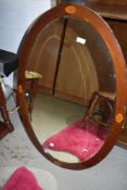 An Edwardian mahogany oval wall mirror