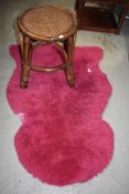 A vintage pink shaggy rug and canework stool