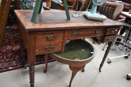A Victorian kneehole desk having part skiver top and turned legs