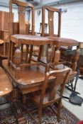 An early 20th Century oak drawer leaf dining table and four chairs, having bulbous legs