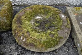 A circular doughnut shaped carved stone shallow water feeder or bird bath