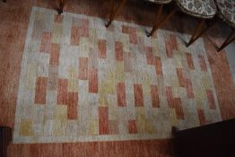 A modern carpet square having geometric terracotta and cream design 230 x 166 cm