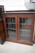A late 19th or early 20th Century low bookcase having leaded glass doors