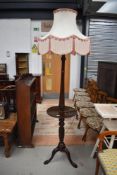 An early 20th Century mahogany standard lamp table having turned column and triple splay legs
