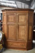 A stripped oak canted cupboard having interior shelves and drawer to base
