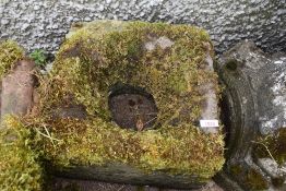 A hand carved stone water drain cover or similar