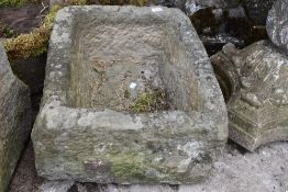 A stone carved planter having holes to base