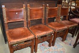 A set of four period oak and leather chairs with brass stud work