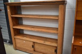 A stripped bookshelf with cupboard base having sliding doors