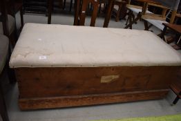A traditional bedding box, pine with overstuffed top , width approx. 122cm Bearing label for