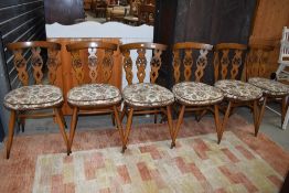 A set of six Ercol dining chairs, fleur de lys style backs, mid/dark colour