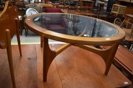 A vintage teak and glass top circular coffee table