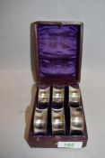 Six early 20th century napkin rings having etched number to each, nestled in purple velvet lined