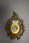 A late 19th / early 20th century portrait miniature on ceramic or similar in ornate brass frame.