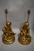 Two brass table lamps with gold tone composite cherubs to bases.