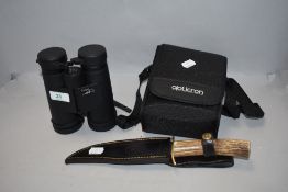 A pair of Oregon 10x42 field binoculars and a traditional bowie knife with horn handle