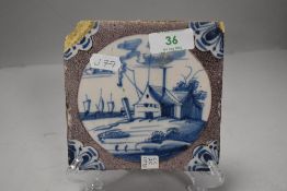 A 18th century Dutch delft tile depicting a boat house with ships and sea