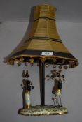 A mid century table lamp,having ceramic base with two ethnic figures.