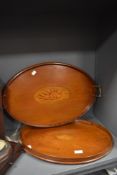 Two Edwardian mahogany oval galleried trays , having inlaid cornucopia shell design , one having
