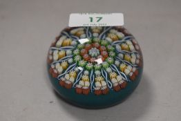 A modern millefiori glass art studio paper weight by Perthshire bearing makers cane on teal