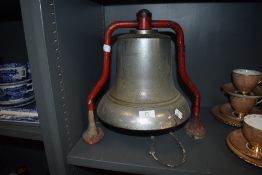 A 1950's fire station alarm bell having red metal bracket and large bell with ringer