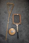 A vintage LaCrosse stick, tennis racket and discus