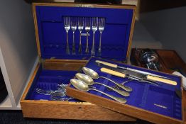 An oak cased canteen,around 1930s having a mixed collection of cutlery inside including bone handled