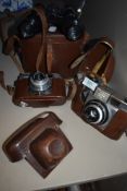 Two vintage cameras, and Agfa and a Yoightlander, and a set of binoculars.