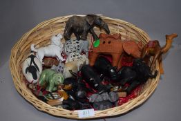 A basket full of mixed animal studies including caved wooden camel,terracotta elephant, carved