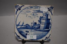 A 18th century Dutch delft tile depicting man fishing by a European villa with boats