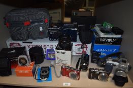 A selection of cameras and camera equipment to include Vivitar lens, Lumix and Dimage 7 cameras.