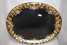 A large Victorian papier mache tray decorated with gilt and mother of pearl inlay