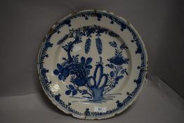 A 18th century Dutch delft charger bowl decorated with floral chinoiserie pattern
