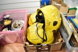 Two modern fireman helmets with fold down visors both having seen action