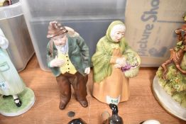 A pair of Coalport figures in bisque glazes of a flower seller and wandering man