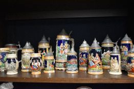 A selection of German beer steins mugs and tankards most having pewter lids with embossed hand