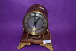 An Edwardian barrel or port hole style clock in heavy ormolu case on lions paw feet by Smiths