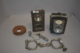 Two vintage cycle or motor car lights, a pair of Hiatt handcuffs with police style whistle etc