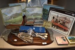 A collection of boxed place mats, a serving platter with bull detail to ends, and a mixed bundle