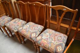A set of four vintage pine dining chairs having shaped rail backs and turned legs