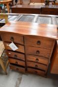 A modern hardwood shallow chest of 10 merchant drawers in a side by side arrangment, serpentine