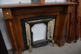A stained frame fire surround and reproduction Art Nouveau style cast iron and tiled fireplace