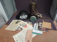 A WW2 Gas Mask in tin with inner liner, a Tin Helmet and a collection of reproduction Ephemera incl