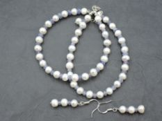 A string of cultured pearls with rough cut tanzanite spacers and matching drop earrings all having